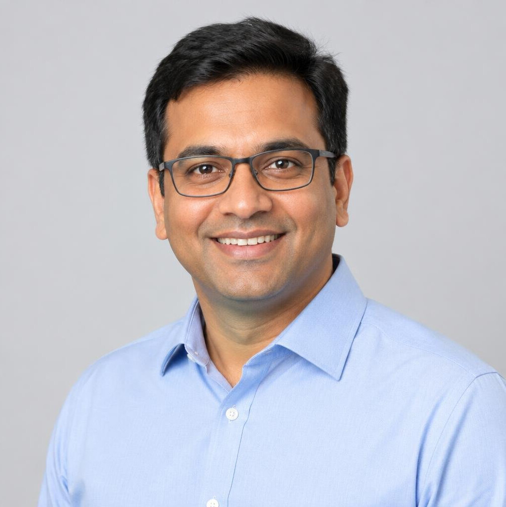Studio portrait of a smiling man with glasses in a light shirt